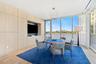 Full-height light wood-finish cabinetry, built-in media alcove, floor-to-ceiling glass wall, recessed lighting, and herringbone wood-finish flooring