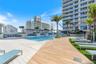 Swimming pool with a sun shelf, paved pool deck, wood-finish decking, integrated landscaping, and built-in pergola structures
