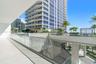 Covered terrace featuring glass panel railings, large-format tile flooring, and decorative metal screen privacy panels