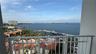 Covered balcony with white metal railings overlooking a coastal waterway and marina