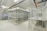 Secure, dedicated wire-mesh storage units with integrated elevated shelving and concrete flooring