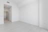 High-ceiling interior featuring smooth white walls, large-format tile flooring with marble-style veining, recessed lighting, and solid-core interior d