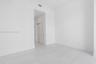Interior space featuring large-format rectified tile flooring, recessed ceiling lighting, and double-panel sliding closet doors