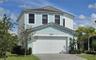 Two-story exterior featuring light-toned stucco siding, a tiled roof, a multi-panel garage door, and a paved driveway