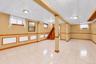 Finished lower-level space featuring tile flooring, wooden chair rail trim, recessed lighting, and a drop ceiling