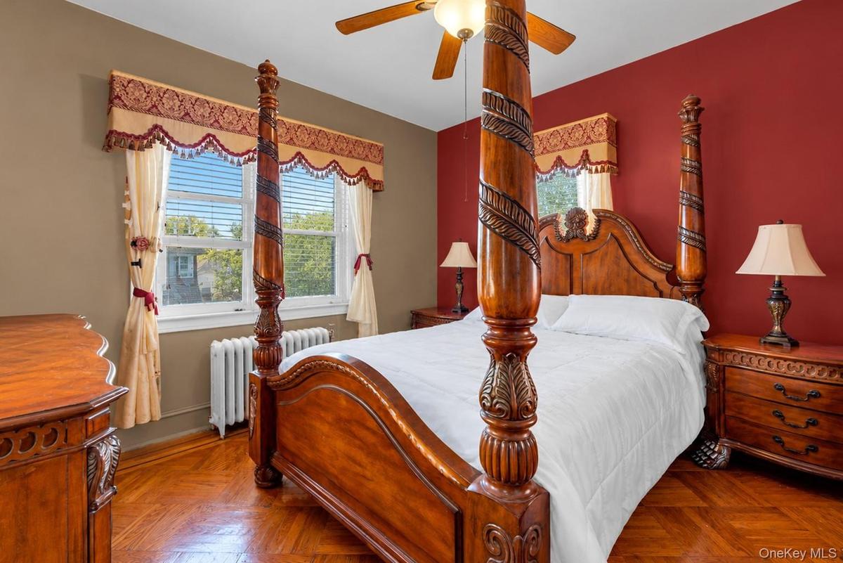 Parquet hardwood flooring, dual-tone wall finishes, and a ceiling-mounted fan with integrated lighting