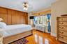 Wall-to-wall built-in wood cabinetry, parquet flooring, triple-pane window configuration, and an integrated ceiling fan with multi-light fixture