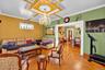 Coffered ceiling with decorative molding, intricate wood-finish parquet flooring, crystal chandelier, and stained-glass window accent