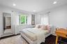 Neutral-toned room featuring dark-finish hardwood flooring, recessed lighting, and multiple windows