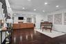 Dark wood-finish flooring, recessed lighting, arched wall opening, and a fireplace with a decorative mantel
