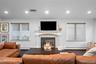 Fireplace featuring a mosaic tile surround, decorative columns, and a mantle, accented by dark wood-finish flooring and recessed lighting