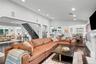 Vaulted ceilings, wood-finish flooring, recessed lighting, and a fireplace with a decorative mantle