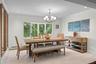 Dining area featuring light-toned flooring, multi-pane casement windows, a multi-arm chandelier, and crown molding