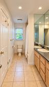 Dual vanity with integrated sinks, recessed lighting, tile flooring, window with blinds, and full-wall mirror