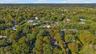 Aerial perspective highlighting a rectangular parcel characterized by mature tree coverage and a private wooded setting