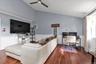 Vaulted ceilings, wood-finish flooring, two-tone walls with chair rail molding, and a ceiling fan