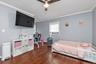 Interior space featuring wood-finish flooring, crown molding, and a central ceiling fan with integrated lighting
