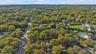 Aerial view of a rectangular lot defined by mature trees and natural landscape