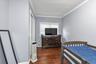 Room featuring wood-finish flooring, crown molding, and a window with horizontal blinds