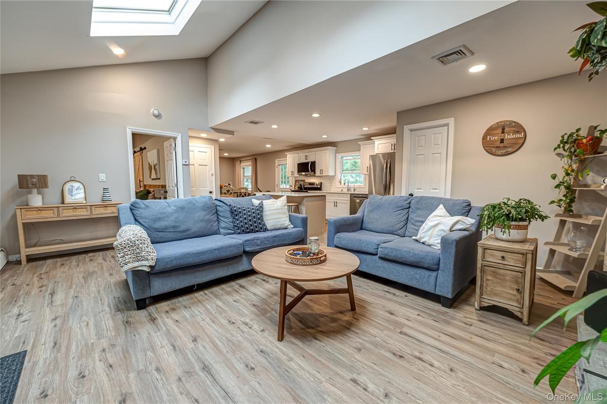 living area into kitchen with bedroom entrance and skylights