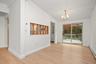 Interior space featuring wood-finish flooring, a decorative spindle pass-through, a multi-arm chandelier, and sliding glass doors with access to an ex