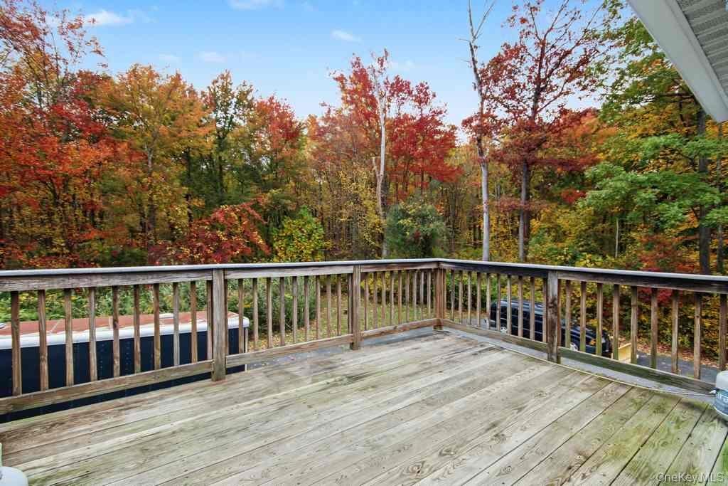 Deck off dining room! Wood deck featuring perimeter balusters and backdrop of mature deciduous trees