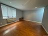 Spacious room featuring wood-finish flooring, recessed lighting, and a large window with integrated blinds