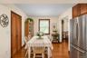 Kitchen area featuring wood-finish flooring, stainless steel refrigerator, wood-toned cabinetry, and double-door pantry