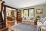Hardwood flooring, natural wood trim, and a prominent staircase with a curved lower tread