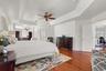 A second view of the impressive primary suite highlights its spacious layout, beautiful natural light, and seamless connection to a private sitting ar