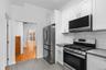 Kitchen featuring white shaker-style cabinetry, stainless steel appliances, a gas range with an over-the-range microwave, solid-surface countertops, a