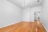 High ceilings featuring a crystal chandelier and light-toned wood-finish flooring