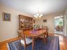 Dining area featuring wood-finish flooring, a multi-arm brass chandelier, and built-in wood cabinetry