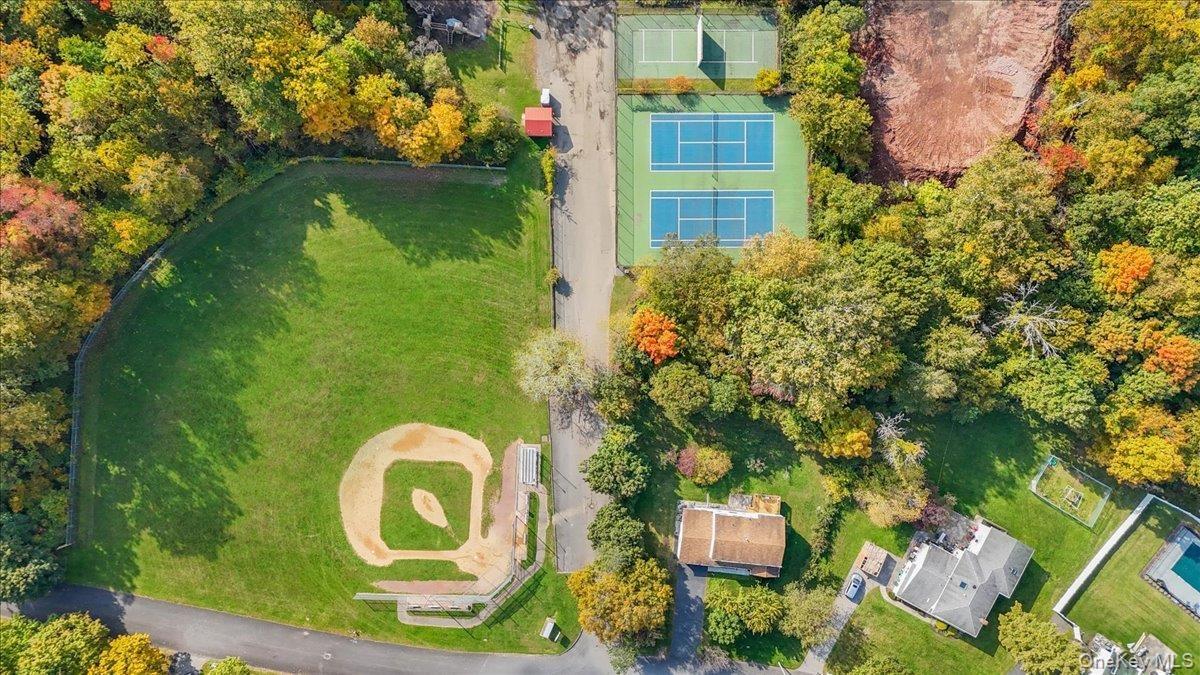 Aerial perspective featuring two dedicated tennis courts and a baseball field with a grass infield