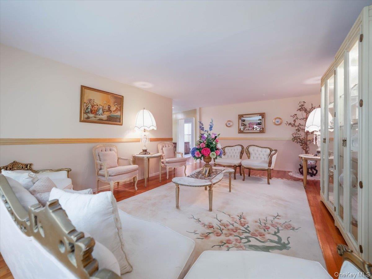 Interior room featuring hardwood flooring, chair rail molding, and a built-in floor-to-ceiling glass-front display cabinet