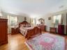 Expansive room featuring wood-finish flooring, neutral wall paint, and multiple windows with exterior exposure