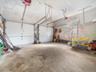 Two-car garage featuring dual overhead doors, concrete flooring, and a single window