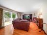 Living room featuring wood-finish flooring, a built-in media cabinet, and large glass sliding doors