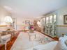 Living area featuring wood-finish flooring, custom built-in glass display cabinetry, and two-tone wall finish with chair rail molding