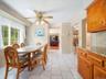 Dining area featuring tile flooring, a multi-light ceiling fan, and natural light from large windows