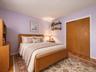 Virtual staged - Wood-finish flooring, dual-panel closet doors, and wall-mounted shelving