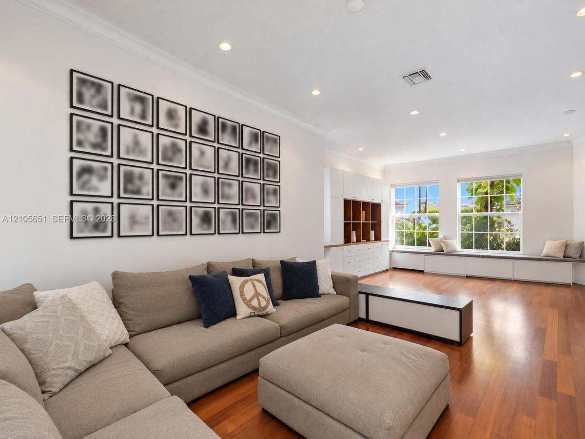 Living space featuring wood-finish flooring, recessed lighting, built-in cabinetry, and window seating