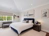 Vaulted ceilings, crown molding, recessed lighting, multi-pane windows, and a built-in floating wall shelf