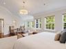 Vaulted ceilings, wood-finish flooring, recessed lighting, multi-pane windows, and a central drum chandelier