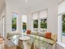 Built-in corner bench seating, expansive bay windows, crown molding, and stone-finish flooring