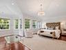 Vaulted ceilings with recessed lighting, wood-finish flooring, multi-pane windows, and a central drum chandelier