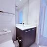 Bathroom featuring a vanity with a white countertop and rectangular undermount sink, chrome faucet, full-height wall mirror, and dark-finish cabinetry