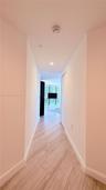 Hallway featuring neutral-toned walls, wood-finish tile flooring, and recessed ceiling lighting