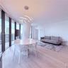 Floor-to-ceiling windows, wood-finish flooring, sculptural LED pendant lighting, and a neutral color palette