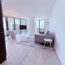 Floor-to-ceiling windows, wood-finish tile flooring, recessed ceiling lighting, and contemporary pendant fixture